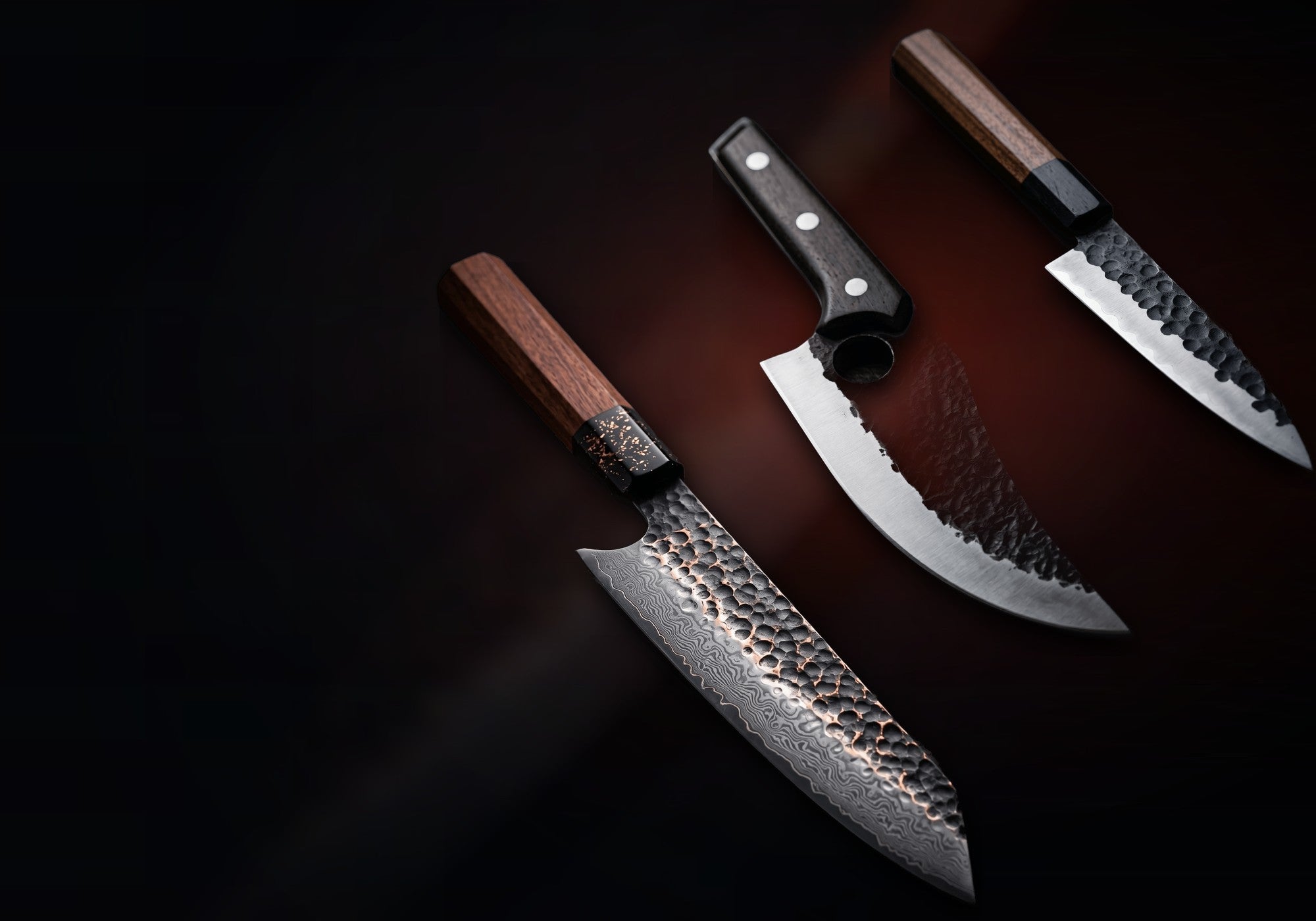 Les trois couteaux NAKUMI — Gyuto Signature en acier damassé 67 couches, Le Boucher robuste et Petty Compagnon damassé, lames forgées à la main au Japon